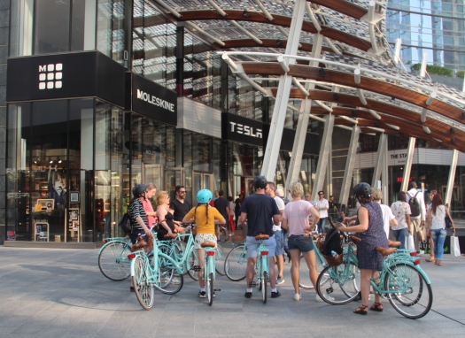 A group of tourists on a guided bicycle tour of Milan, Piazza Gae Aulenti
