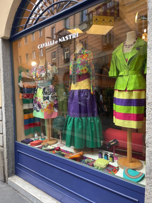 Colourful vintage outfits in thrift store Cavalli e Nastri shop window